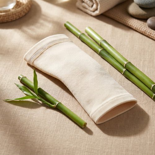 BambooFlex bamboo knee sleeve on warm beige linen surface